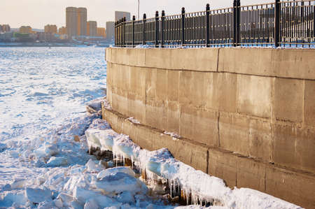 The outer part of the embankment with fragments of the ice cover of the Amur River. Morning at the end of winter. Icicles and ice shards. Huge crack. The border between the states of Russia and China.の写真素材