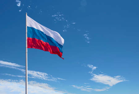 Waving Russian flag against a blue sky with clouds and empty space for text. Room for text. National flag of the Russian Federation.の写真素材