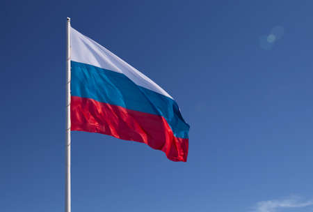 Russian flag on a background blue sky. lens flare effect.の写真素材