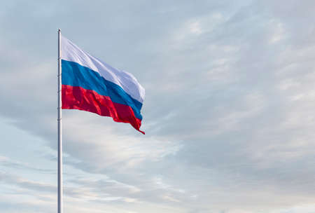 Waving Russian flag against a blue sky with clouds and empty space for text. Room for text. National flag of the Russian Federation.の写真素材