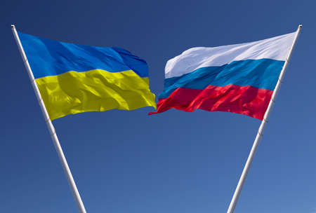 Flags of Russia and Ukraine against a blue sky. Escalation of the conflict. The concept of confrontation. Abstract collage.の写真素材