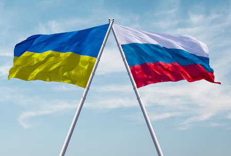 Flags of Russia and Ukraine against a dramatic cloudy sky. Escalation of the conflict. The concept of confrontation. Abstract collage.の写真素材