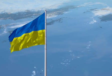 Waving Ukraine flag against a blue sky with clouds and empty space for text. copyspace.