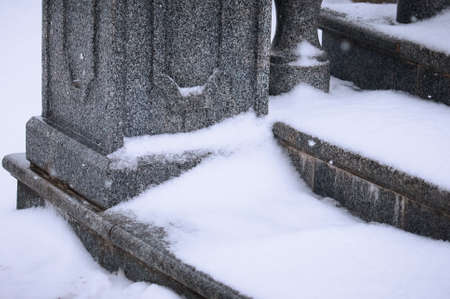 A close view of the granite steps under the snow. Balustrade stairs on the embankment on a winter morning during a snowfall. selective focus.の写真素材