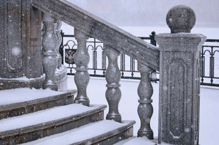 Balustrade of the rotunda under the snow. Gray exterior details during a snowfall. Fragment of a city landmark in winter. selective focus. Blagoveshchensk, Russia.の写真素材