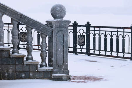 Balustrade of the rotunda under the snow. Gray exterior details during a snowfall. Fragment of a...
