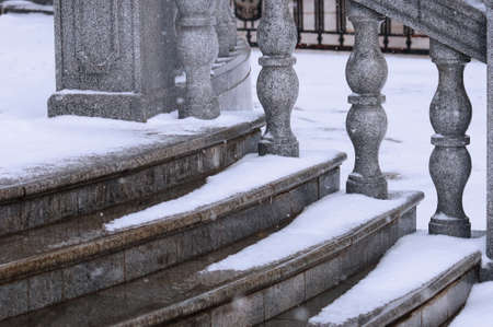 Balustrade of the rotunda under the snow. Gray exterior details during a snowfall. Fragment of a city landmark in winter. selective focus. Blagoveshchensk, Russia.の写真素材