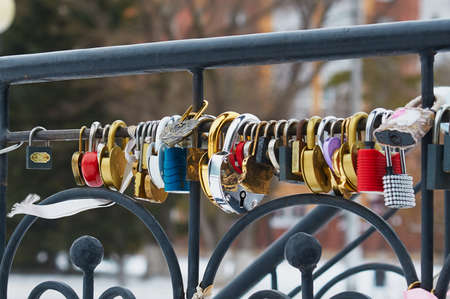 Padlocks on fence railings. Wedding traditions of different people of the world. selective focus. Various types of Love Padlocks.の写真素材