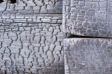 Fragment of a burn log hut. After the fire. Texture of charred wood. selective focus.の写真素材