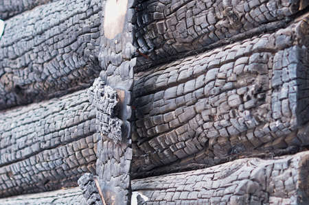 Fragment of a burn log hut. After the fire. Texture of charred wood. selective focus.の写真素材