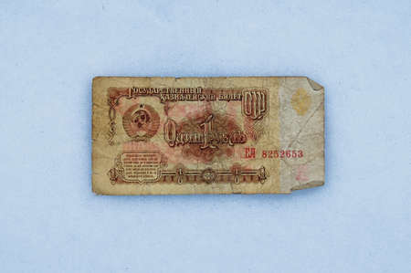 Banknote of the old Soviet ruble in the snow. Old crumpled paper on fresh texture background. Close-up view from above.の写真素材