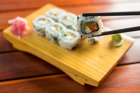 Eating Japanese sushi with chopsticksの写真素材