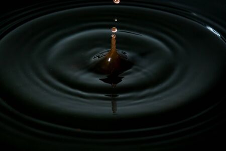 water drop splash in a glass, black backgroundsの写真素材