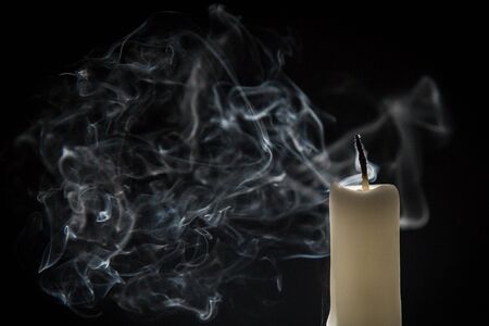 Smoke and extinct candle on a black backgroundの写真素材