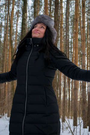 beautiful girl in a fur coat in the winter in the Park the sun