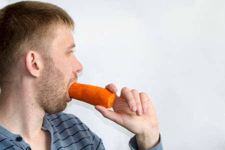guy eats carrots on a white background
