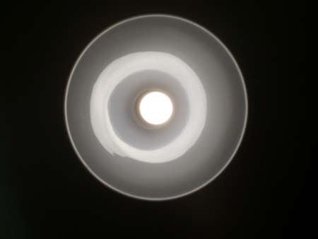 the lamp in the luminaire, viewed from the bottom on a black backgroundの写真素材
