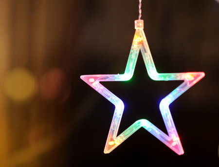 Closeup of Festively Decorated Outdoor Christmas tree with bright red balls on blurred sparkling fairy background. Defocused garland lights, Bokeh effect. Defocused night city street, cars on road.の写真素材