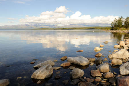 The peaks of the mountains, the Khibiny and a clear, bright sky with white clouds. View of the khibiny mountains from afar. Lake Imandra in summer. Kola Peninsulaの写真素材