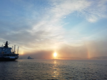 Ships in the port of Murmansk. Winter cold, the setting sun on a beautiful sky. Murmansk is a port city.の写真素材
