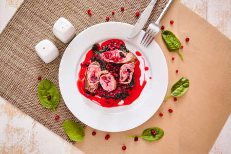 Beautiful meatloaf with cranberry sauce and spinach. Piece of art. Top viewの写真素材