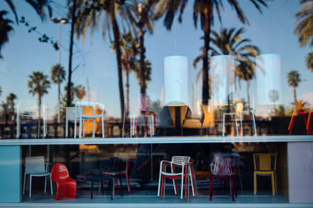 reflection of the sky and palm trees in the window of a furniture storeの写真素材