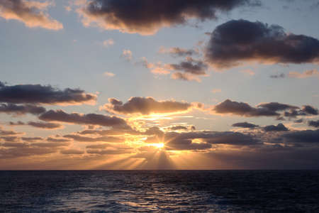 dramatic clouds sea sunset with sunraysの写真素材