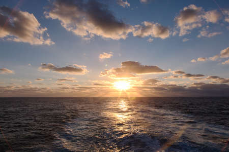 dramatic clouds sea sunset with sunraysの写真素材