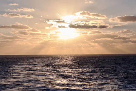 dramatic clouds sea sunset with sunraysの写真素材