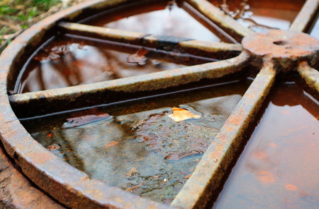The old rusty hatch cover after the rain. Old rusty hatch cover in autumn