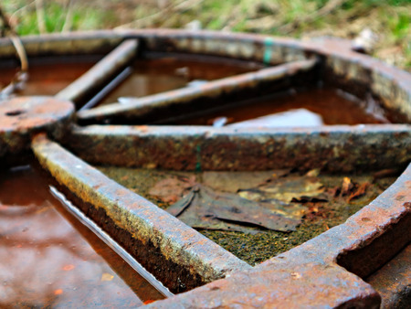 The old rusty hatch cover after the rain. Old rusty hatch cover in autumn