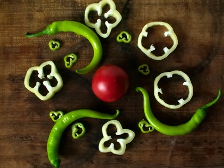Sliced sweet and bitter pepper on a wooden board or wooden trayの写真素材