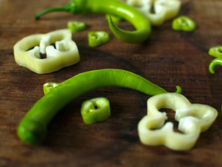 Sliced sweet and bitter pepper on a wooden board or wooden trayの写真素材