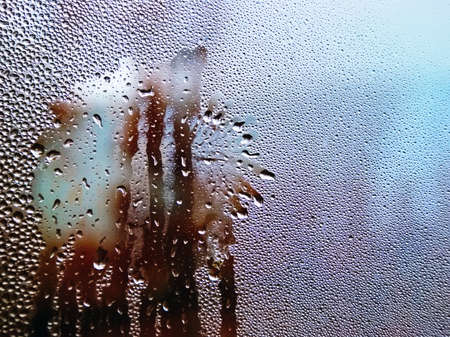 Drops of water on a cold glass. Condensate on glass