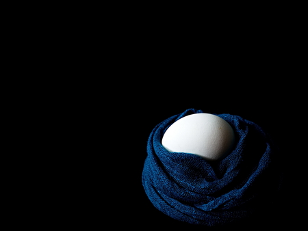 The egg lies in a scarf. Egg. Easter. Eggs in colored scarves.
