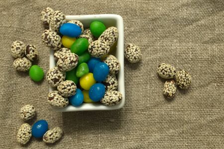 Multicolored round candy lying on the burlap. Multi-colored candies dragee. Small round candyの写真素材