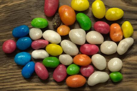 Multicolored round candy lying on the burlap. Multi-colored candies dragee. Small round candyの写真素材