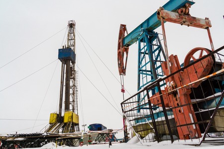 Oil and Gas Drilling Rig onshore dessert with dramatic cloudscape. Oil drilling rig operation on the...