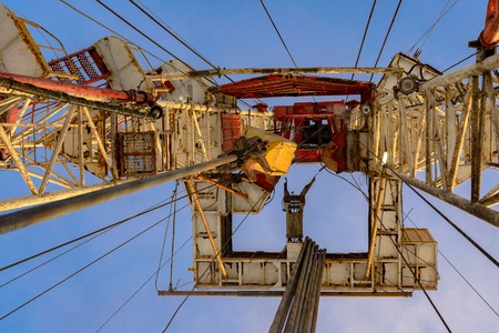 Oil and Gas Drilling Rig onshore dessert with dramatic cloudscape. Oil drilling rig operation on the oil platform in oil and gas industry. Land drilling rig blue skyの写真素材