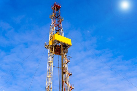Oil and Gas Drilling Rig onshore dessert with dramatic cloudscape. Oil drilling rig operation on the...