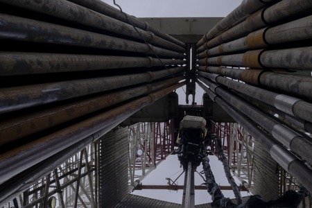 Oil and Gas Drilling Rig onshore dessert with dramatic cloudscape. Oil drilling rig operation on the oil platform in oil and gas industry.の写真素材