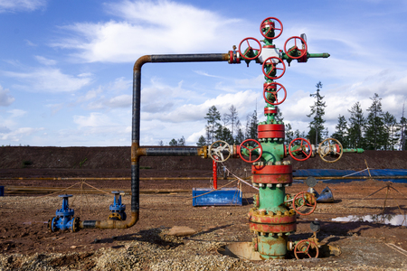 Horizontal view of a wellhead with valve armature. Oil and gas industry concept. Industrial site background. Toned.の写真素材