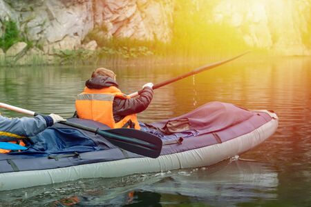 A young boy sits at the very front of the raft. Rafting on the river Belaya. Sunny day, clouds. Russia.の写真素材