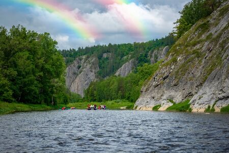 A group of friends in an inflatable raft moving down a river. Mountain river water landscapeの写真素材