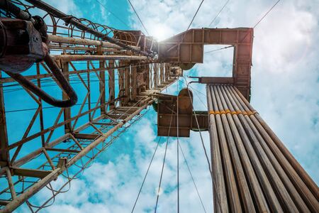 Oil and Gas Drilling Rig onshore dessert with dramatic cloudscape. Oil drilling rig operation on the oil platform in oil and gas industry.の写真素材