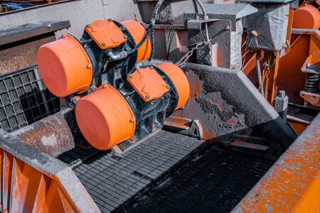 Shale shaker on an offshore oil rig. Shale shaker screen close up view with drill cutting flow out from oil base mud. Separators are end. Equipment for oil separationの写真素材