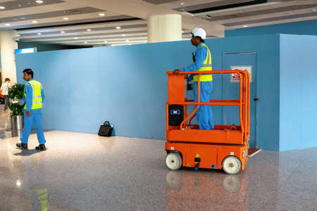 DUBAI, UAE - MARCH 24: Orange hydraulic scissor platform stand by for service and maintenance in work area.のeditorial素材