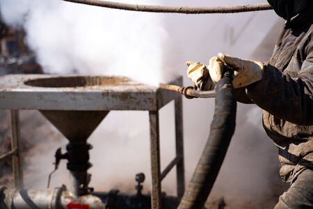 Worker use high pressure steam jet to cleaning splashing the dirt of tube bundle in industrial...