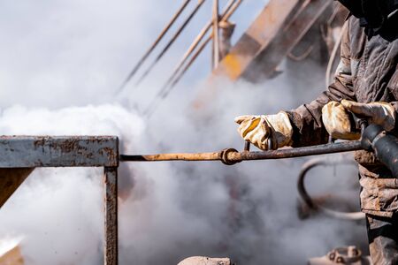 Worker use high pressure steam jet to cleaning splashing the dirt of tube bundle in industrial...