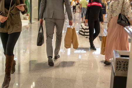 Young man shopping in the mall with many shopping bags in his hand.の写真素材